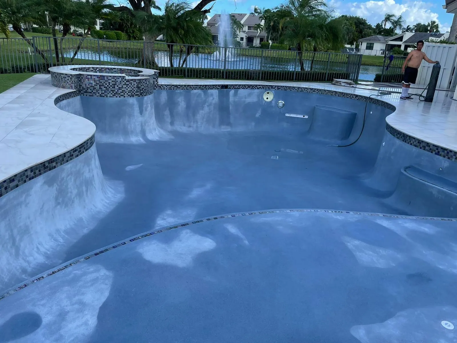 Curved pool and raised spa with a new gray-blue interior finish.