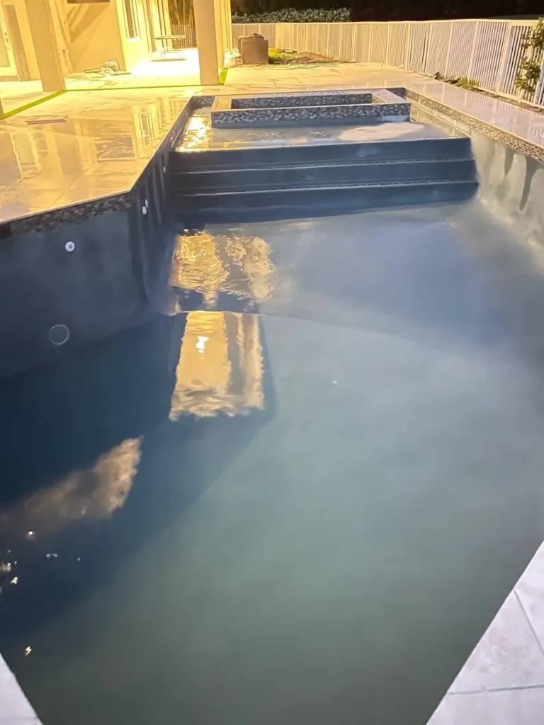 Pool with wide entry steps and a new finish in warm evening light.