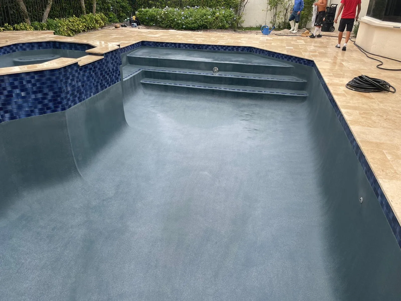 Pool entry steps with a blue waterline tile band and a fresh finish.