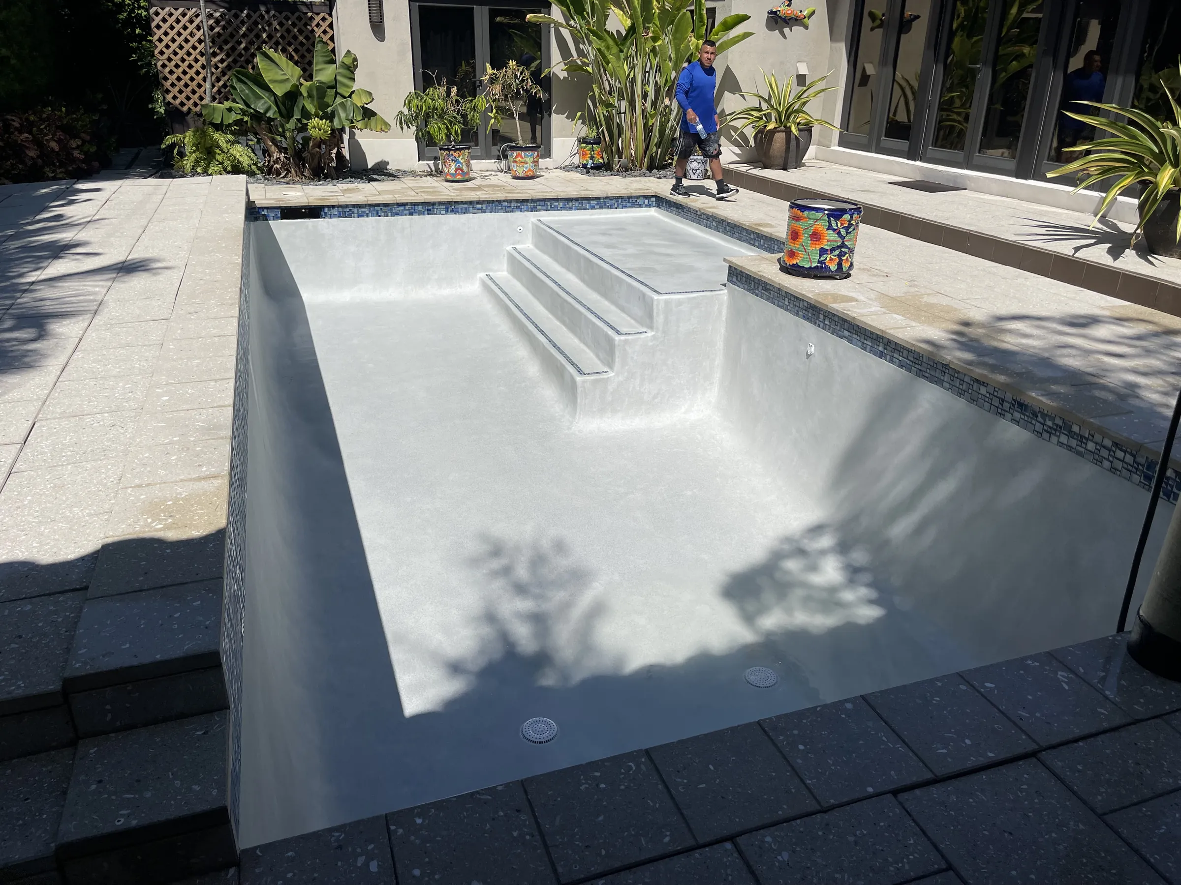 Rectangular pool with a fresh white plaster finish and wide entry steps.